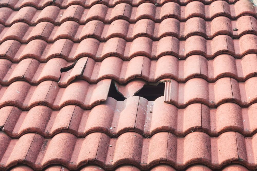 Storm-damaged roof with broken tiles ahead of insurance repair work